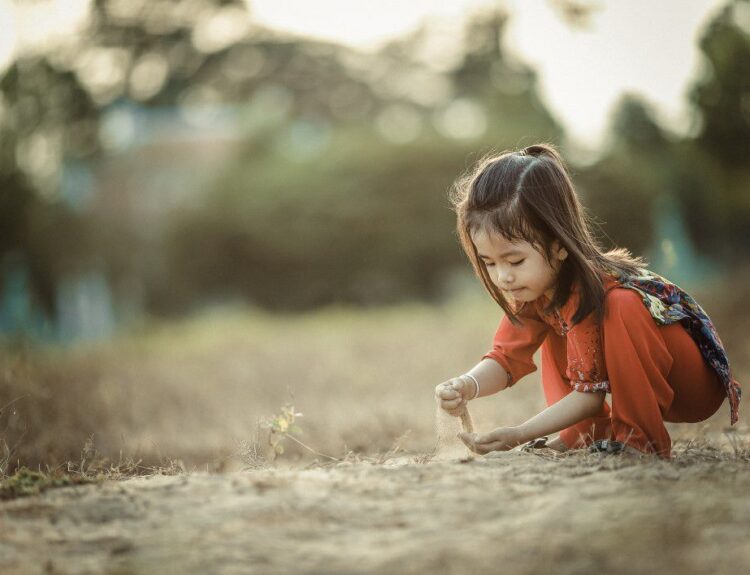 Child playing with sand, highlighting the childhood amnesia.