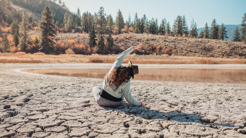 A woman sitting among nature and doing yoga for mind health.